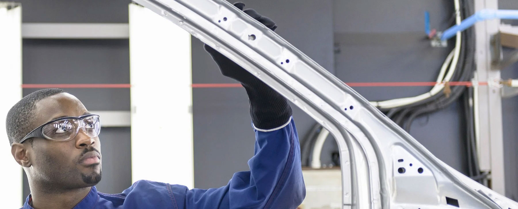 a man inspecting the frame of a car