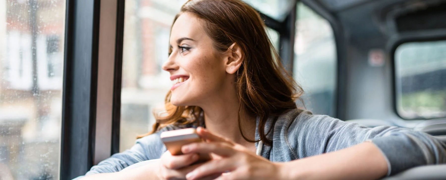 A woman smiling using her phone