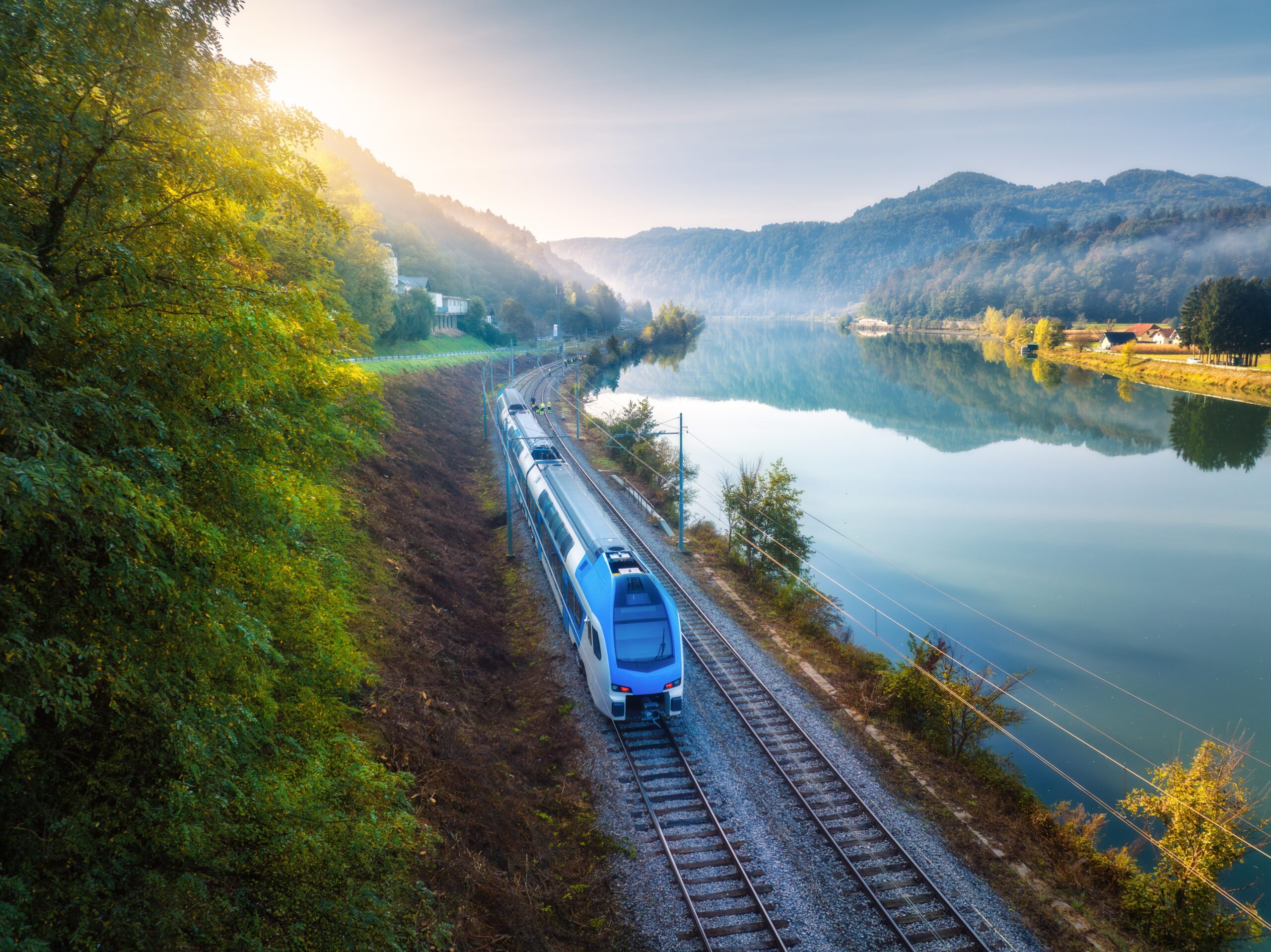 Aerial,View,Of,Blue,Modern,High,Speed,Train,Moving,Near A woman pumping gas